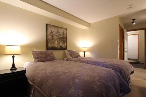 a bedroom with a bed with two lamps on it at Glacier's Reach by Whistler Retreats in Whistler