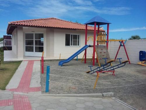 un parque infantil con un tobogán frente a una casa en AP de Praia Mar Azul - Praia da Vila, en Imbituba