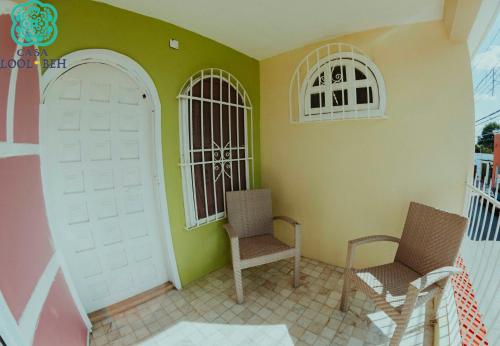 a room with two chairs and a white door at Casa Lool Beh in Mérida