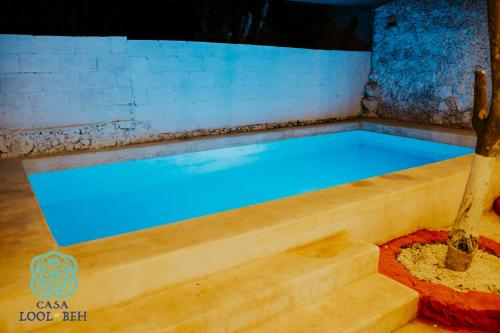 a pool with blue water in a wooden tub at Casa Lool Beh in Mérida