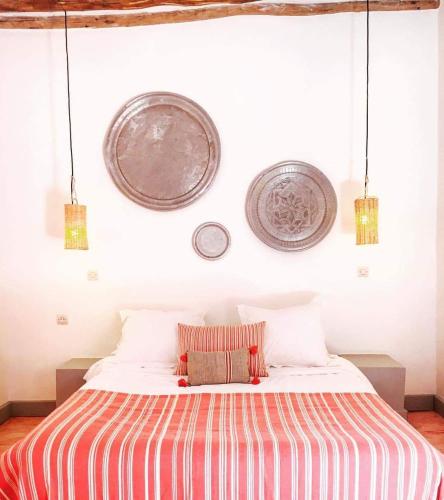 a bedroom with a bed with plates on the wall at Art Riad Au Bord De La Mer in El Jadida