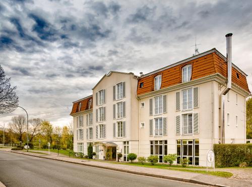 un gran edificio blanco al lado de una calle en Hotel Rosenhof bei Bamberg, en Kemmern