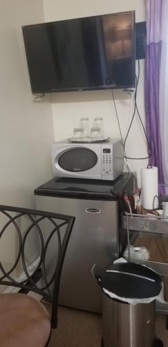 a microwave sitting on top of a refrigerator in a room at Dominique's Getaway NYC in Bronx