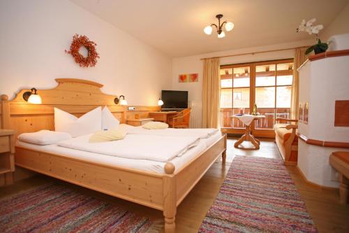 a bedroom with a large bed and a desk at Beim Nuihausa in Reit im Winkl