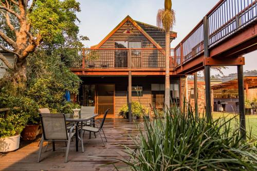 a house with a deck and a table and chairs at Jetz Bungalow in Berrara