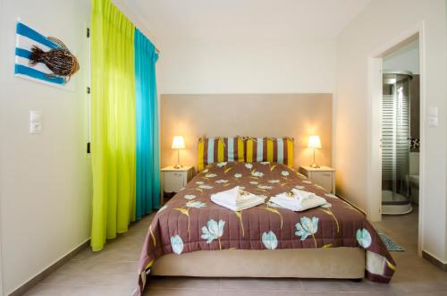 a bedroom with a bed and two lamps on two tables at Papafragas Studios in Pachaina