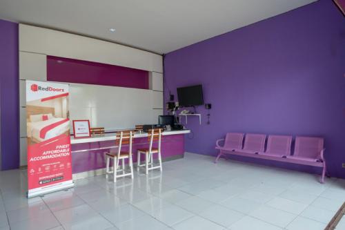 a room with purple walls and a table and chairs at RedDoorz near Alun Alun Kaliwungu Kendal in Brangsong