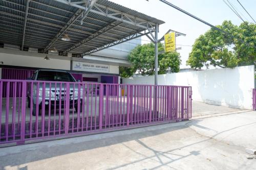 a purple gate in front of a parking lot at RedDoorz near Alun Alun Kaliwungu Kendal in Brangsong