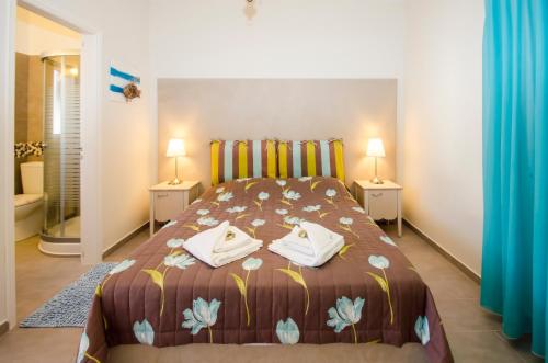 a bedroom with a bed with two night stands and two lamps at Papafragas Studios in Pachaina