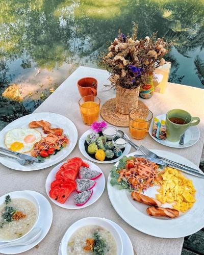 a table topped with plates of food and drinks at House Of Passion Amphawa in Amphawa