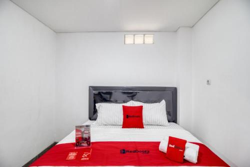 a bedroom with a bed with red and white pillows at RedDoorz Syariah near Galeria Mall Yogyakarta in Yogyakarta