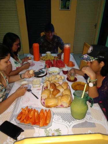 un gruppo di persone seduti intorno a un tavolo con cibo di Pousada Jerusalém a Carolina