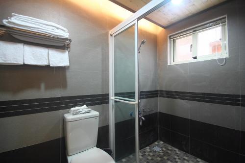 a bathroom with a toilet and a glass shower at Jimei Homestay in Jian