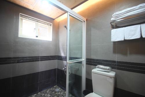 a bathroom with a toilet and a glass shower at Jimei Homestay in Jian