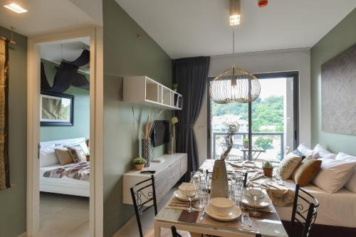 a dining room and living room with a table and a couch at Unixx Pattaya by Chanakan in Pattaya South