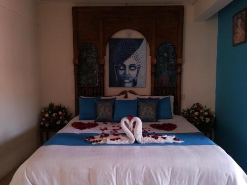 a bedroom with a bed with a statue of a woman at Ganesha Hotel in San Cristóbal de Las Casas