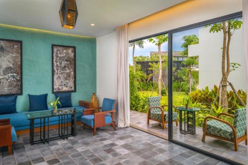 a lobby with chairs and tables and sliding glass doors at The Villa by Metta in Siem Reap