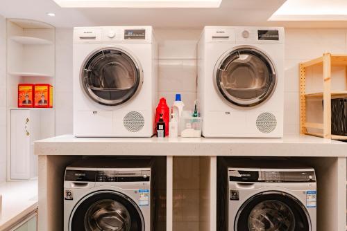 three washers and dryers in a laundry room at Paco Hotel Guangzhou Zoo Metro Branch in Guangzhou