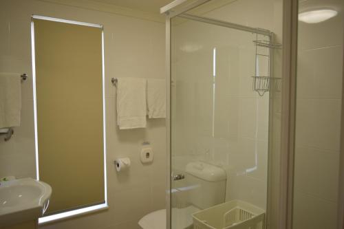 a bathroom with a shower and a toilet and a sink at Glenelg Holiday Apartments - Corfu 200 meters to the beach Free Parking in Adelaide