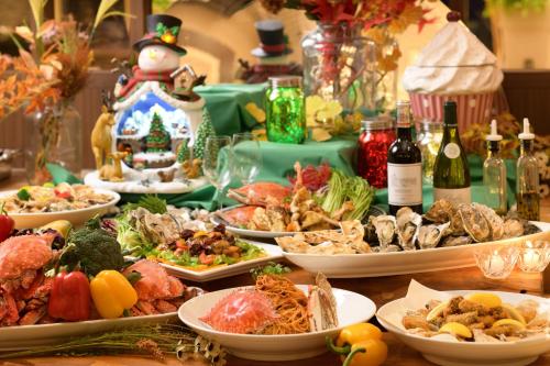a table with many plates of food and bottles of wine at Hotel Matsushima Taikanso in Matsushima