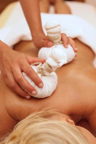a woman getting a massage on her stomach at Christophorus Mountain Residence in San Vigilio Di Marebbe