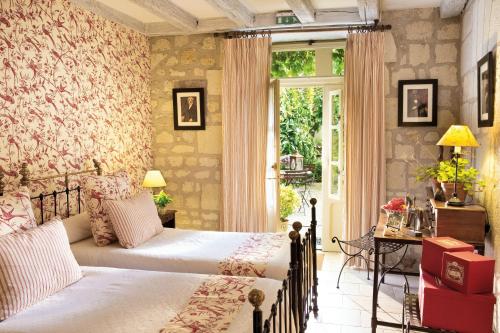 1 dormitorio con 2 camas y ventana en Hôtel Diderot, en Chinon