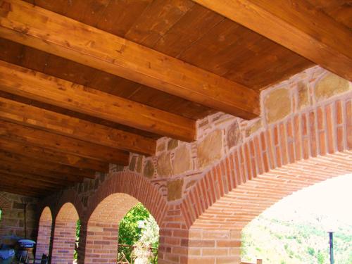 a wooden roof on a brick building with an archway at L'Uliveto in Reitano