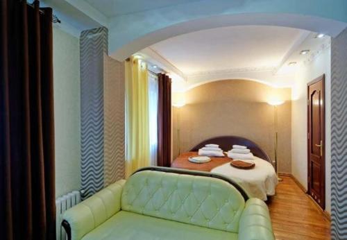 a bedroom with a bed with a couch and a table at VICTOR Hotel Resort & SPA in Truskavets