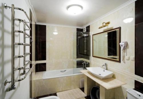 a bathroom with a sink and a bath tub at VICTOR Hotel Resort & SPA in Truskavets