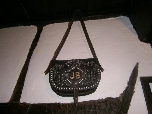 a black purse hanging from a brick wall at Apartamentos Rurales Tía Josefa in Tornavacas