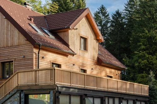 a wooden house with a balcony on the side of it at House Storz in Pohorje