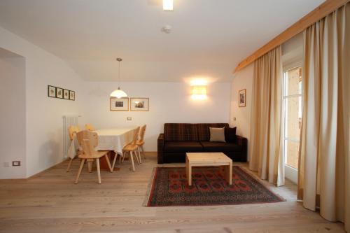 a living room with a couch and a table at Christophorus Mountain Residence in San Vigilio Di Marebbe