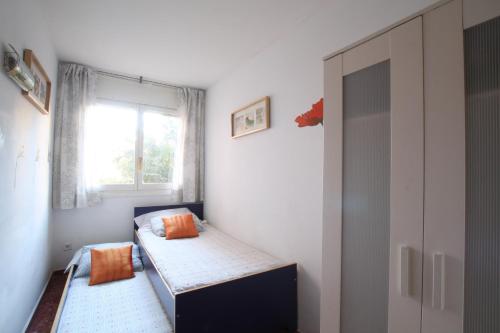 a small room with two beds and a window at Good-Apartments Barcelona in Barcelona