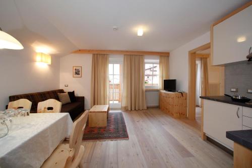 a kitchen and living room with a bed and a couch at Christophorus Mountain Residence in San Vigilio Di Marebbe