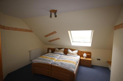 a bedroom with a bed in a attic with a window at Haus Schnorbus in Hallenberg