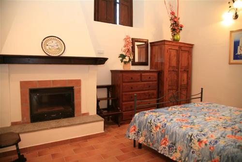 a bedroom with a bed and a fireplace at Agriturismo Toscanella in Montebello