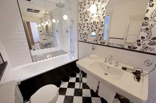 a bathroom with a sink and a toilet and a mirror at Duca D'Aosta Hotel in Aosta