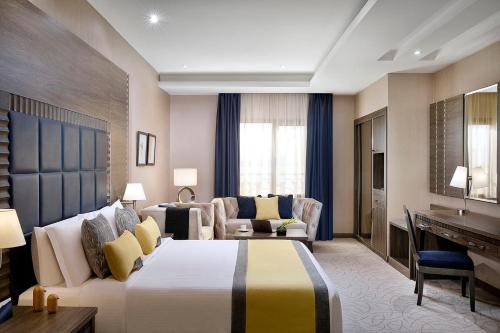 a hotel room with a bed and a couch at voco Al Khobar by IHG in Al Khobar