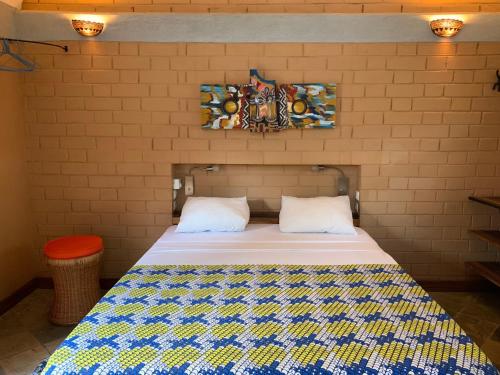 a bedroom with a bed in a brick wall at Hôtel Amédzépé in Palimé