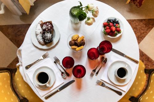 uma mesa branca com pratos de comida e chávenas de café em Ca' Vendramin Zago em Veneza