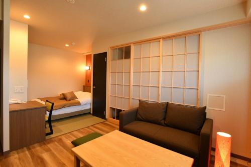 a living room with a couch and a bed at Hotel Imari Aioibashi Bettei in Imari
