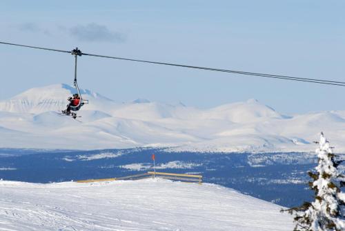 a person on a ski lift in the snow at Kvitfjell Alpinhytter Kvitfjellvegen 492 in Kvitfjell