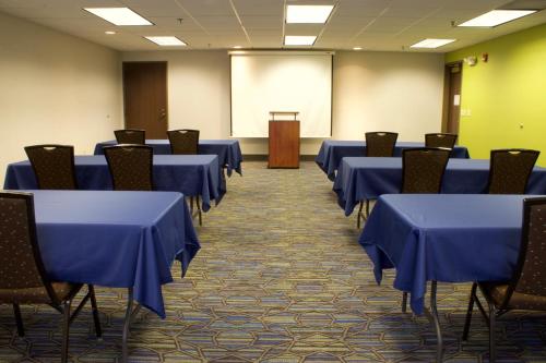a room with blue tables and chairs and a podium at Holiday Inn Express Hotel & Suites-St. Paul by IHG in Vadnais Heights