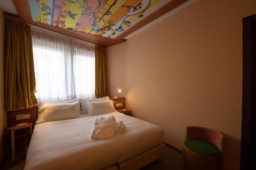 a hotel room with a bed with a painted ceiling at OMAMA Hotel in Aosta