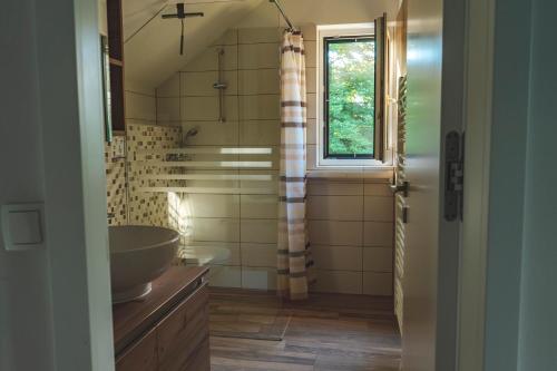 baño con lavabo, espejo y ventana en Hiša Katja-Privat wellness, en Kranjska Gora