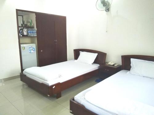 Zimmer mit 2 Betten und einem Kühlschrank in der Unterkunft Trường Chính Sách Công Và Phát Triển Nông Thôn in Ho-Chi-Minh-Stadt