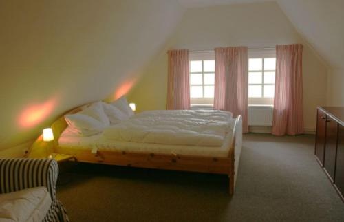 a bedroom with a bed and two windows at Ferienhaus Deichgraf in Vollerwiek