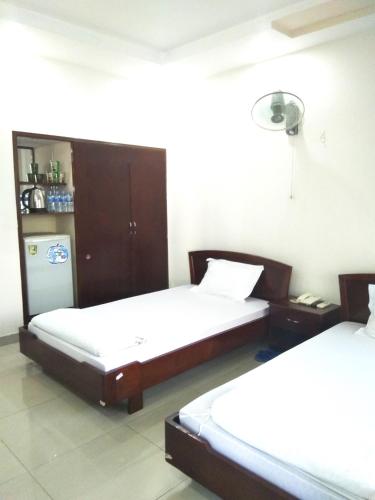 1 Schlafzimmer mit 2 Betten und einem Kühlschrank in der Unterkunft Trường Chính Sách Công Và Phát Triển Nông Thôn in Ho-Chi-Minh-Stadt