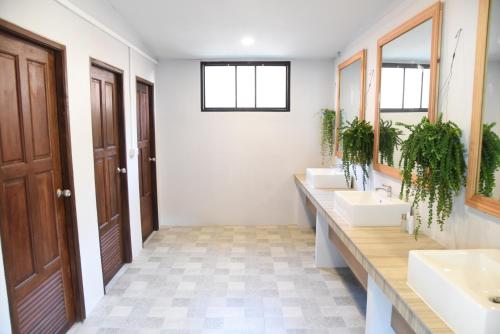 a bathroom with three sinks and two mirrors at Zleepingpills Aonang Krabi in Krabi town