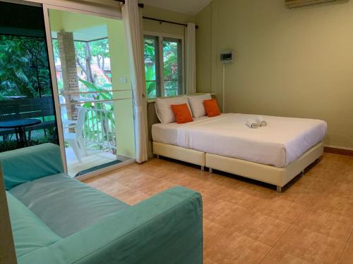 - une chambre avec un lit et un canapé dans l'établissement Khao Yai Cottage, à Mu Si